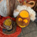 A top down view of the gourd. A candle lights the inside. The top hat sits near. The ghostly hair is attached to the  opening rim. 